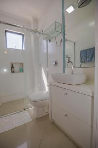 a white bathroom with a sink and a toilet at Arthi - Lindo Apto Central com Garagem in Balneário Camboriú