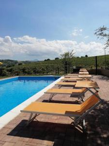 a row of benches sitting next to a swimming pool at AFFITTACAMERE LA QUIETE in San Marcello