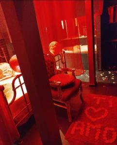 AFFITTACAMERE LA QUIETE في San Marcello: غرفة حمراء بها كرسي وطاولة