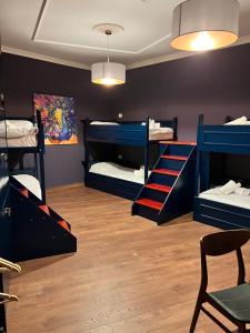 een kamer met 3 stapelbedden en een stoel bij Amo's Hotel in Shkodër +43 foto's