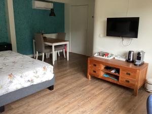 ein Schlafzimmer mit einem Bett und einem Tisch mit einem TV in der Unterkunft Bed & Breakfast De Haere in Doornspijk