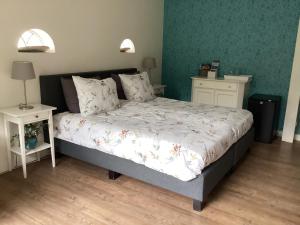 a bedroom with a bed and two night stands at Bed & Breakfast De Haere in Doornspijk