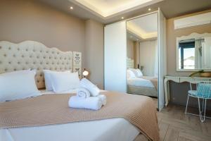 - une chambre avec un grand lit et un grand miroir dans l'établissement The View Hotel Perdika, à Perdika
