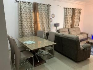 a living room with a couch and a table at Cheerful 3 bedroom bungalow, Fatty Boulevard in Madina Sey Kunda +7 photos