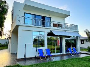 uma casa com cadeiras azuis num deque em Aquamarina Hotel & Villas em Jambiani