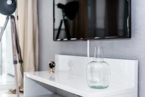 a glass vase sitting on a white counter in a bathroom at Super-Apartamenty International Fair in Poznań