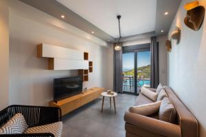 een woonkamer met een bank en een televisie bij The View Hotel Perdika in Perdika