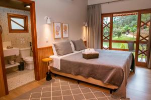 a bedroom with a bed and a bathroom with a toilet at Sítio dos Lagos in Domingos Martins