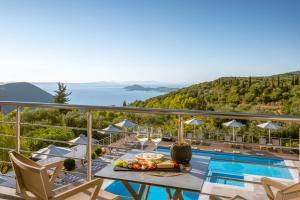 een villa met een zwembad en een tafel met wijnglazen bij The View Hotel Perdika in Perdika