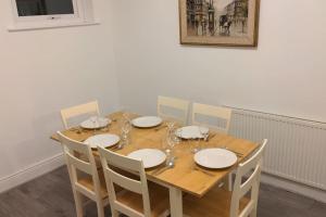 una mesa de madera con platos y copas de vino. en 4 Bedroom Home Near York Racecourse, en York