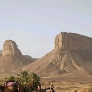 Un uomo a cavallo nel deserto con una montagna di Auberge étoiles iriki a Foum Zguid