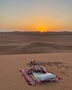 einen Drachen in der Wüste mit Sonnenuntergang im Hintergrund in der Unterkunft Auberge étoiles iriki in Foum Zguid