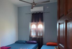 um quarto com 2 camas e uma ventoinha de tecto em Hj Hassan Guest House Bungalow B em Kuala Terengganu