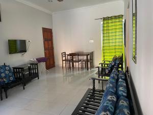 uma sala de estar com um sofá e uma mesa em Hj Hassan Guest House Bungalow B em Kuala Terengganu