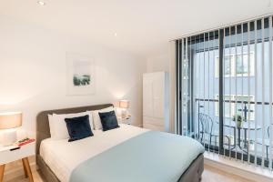 a bedroom with a bed and a large window at Farringdon Apartments in London