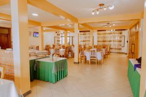 a restaurant with tables and chairs in a room at Pallotti Hotel in Kigali