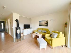 uma sala de estar com um sofá amarelo e uma televisão em PerlePlau em Plau am See
