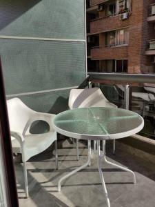- Balcón con mesa de cristal y 2 sillas en Departamento Céntrico muy luminoso y acogedor. en Rosario