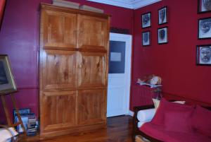 レンヌにあるLa Maison bleueのソファ付きの客室内の大きな木製キャビネット