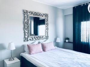 a bedroom with a large mirror above a bed at Kotimaailma Pori City in Pori