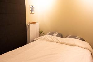 een slaapkamer met een wit bed en 2 stoelen bij Bed en boek in Oudenaarde
