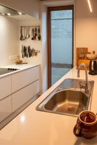una cucina con lavandino e piano di lavoro di Bed en boek a Oudenaarde