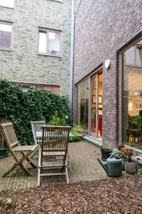 2 sedie sedute su un patio di fronte a una casa di Bed en boek a Oudenaarde