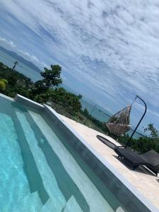 una piscina con un ombrellone e una sedia accanto di VILLA ARGANDA Infinity Pool Luxury Sea View a Bophut