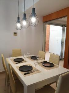 uma mesa de jantar com cadeiras, óculos e luzes em Chalet con piscina privada em Valência