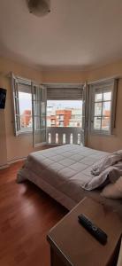 una camera da letto con un grande letto con un tavolo e finestre di EN EL CORAZON DE LA FELIZ CON COCHERA PRIVADA INCLUIDA 3 AMBIENTES LUMINOSO vista al mar a Mar del Plata