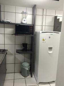 a small kitchen with a microwave and a refrigerator at Park Way Home Service in Recife