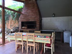 a kitchen with a table and chairs and a fireplace at Posada Enki in Puerto Iguazú