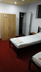 - une chambre avec un grand lit et une armoire en bois dans l'établissement Pensiunea Escape, à Iaşi
