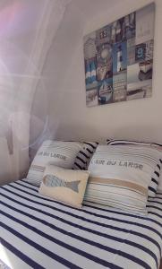 een slaapkamer met een bed met blauwe en witte strepen bij La petite Dieppoise 3 étoiles meublé de tourisme Entre plage et port in Dieppe