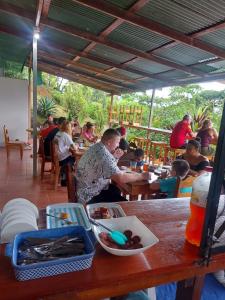 a group of people sitting at a table in a restaurant at Hotel Cabinas Murillo in Drake