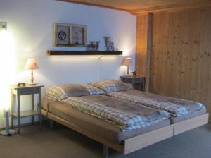 1 dormitorio con 1 cama grande y 2 mesas en Pension Staldacher, en Hasliberg