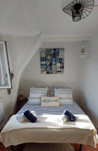 een slaapkamer met een bed met blauwe handdoeken bij La petite Dieppoise 3 étoiles meublé de tourisme Entre plage et port in Dieppe
