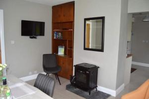uma sala de estar com televisão e fogão em Twin Lake View - Bungalow in Pontoon em Foxford