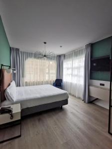 a bedroom with a bed and a large window at Hotel Don Rodrigo in Palencia