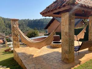 um pátio com uma rede de descanso e um gazebo em Pousada Winterhaus em Monte Verde