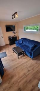 ein Wohnzimmer mit einem blauen Sofa und einem Tisch in der Unterkunft Domki La Bella 3 in Aleksandria
