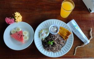 a table with two plates of food and a glass of orange juice at Hotel Cabinas Murillo in Drake