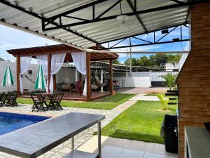 a patio with awning and a table and a pool at Casa Boto Tucuxi 1 in Novo Airão