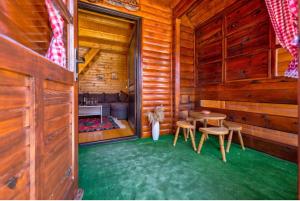 ein Zimmer mit einem Tisch und Stühlen in einem Blockhaus in der Unterkunft Zlatibor Brvnare Zakos in Zlatibor