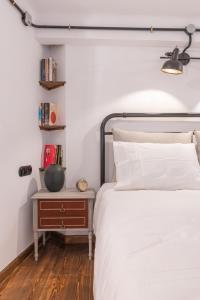 1 dormitorio con 1 cama y mesita de noche junto a la cama en Stoa Kairi Loft B, en Atenas