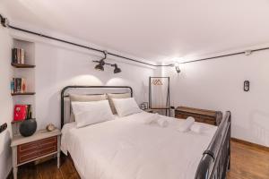 1 dormitorio con 1 cama blanca grande y 2 almohadas blancas en Stoa Kairi Loft B, en Atenas