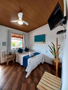 una camera con letto e ventilatore a soffitto di Suites Casa Azul-Vila do Abraão- conforto, limpeza, ótima localização a Abraão