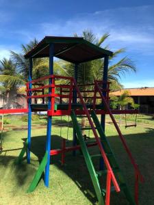 a playground with a colorful slide in the grass at Apartamento em Taiba-CE com vista para o mar in Taíba