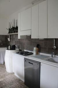 a kitchen with white cabinets and a stove top oven at Casa Sivori sul lago di Garda con ampio giardino in Desenzano del Garda