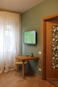 a room with a table and a television on the wall at Casa Sivori sul lago di Garda con ampio giardino in Desenzano del Garda